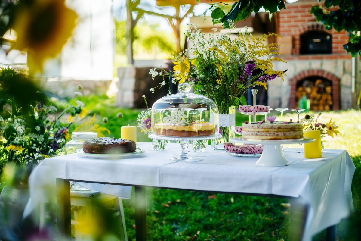 Kuchenbuffet mit Kuchen, Torte und bunten Blumen bei Hochzeit