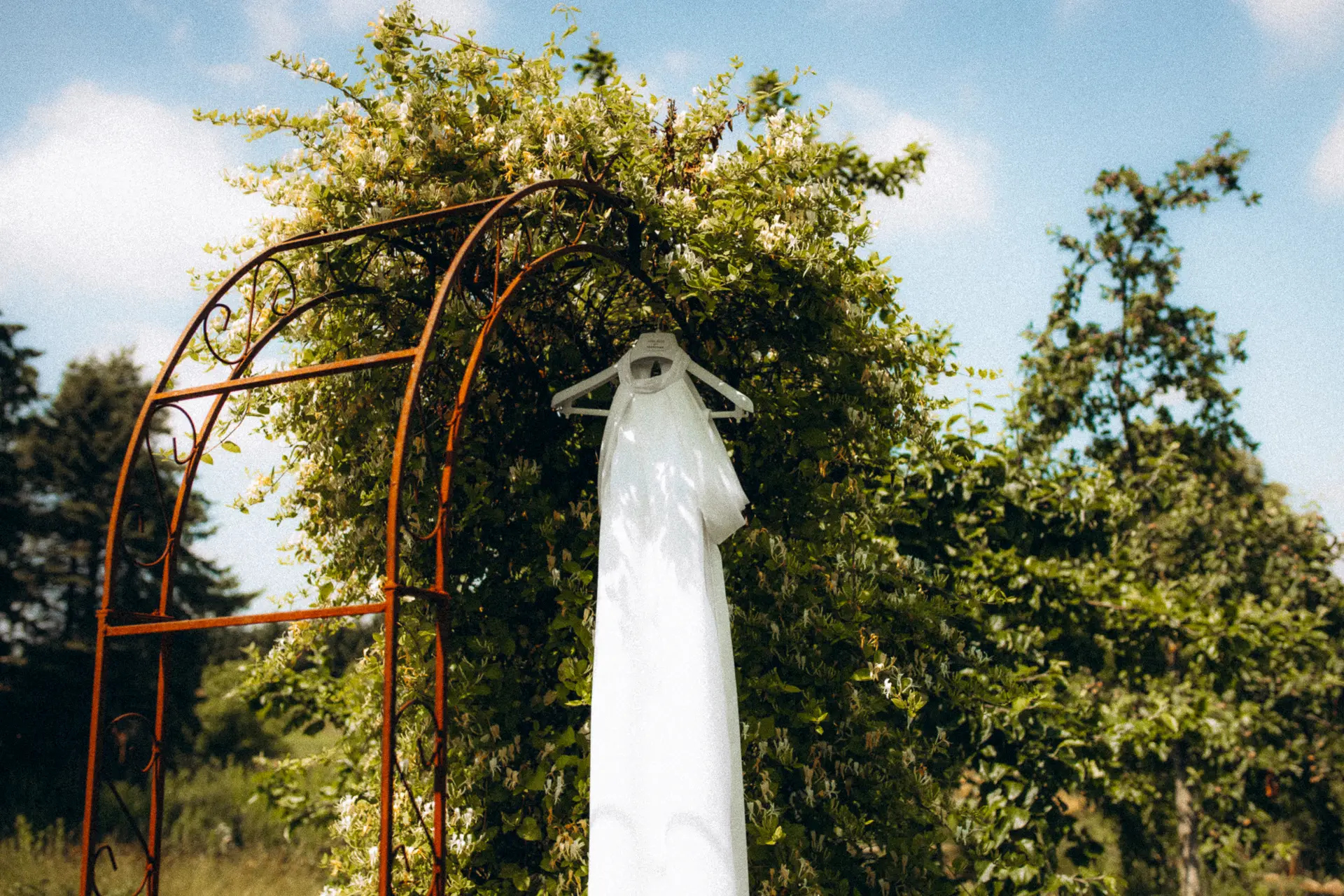 Brautkleid auf Bügel im Terra.Garden an Metalltor