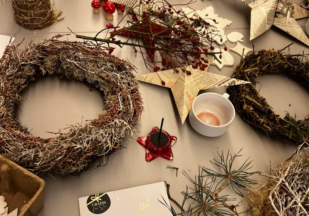 Weihnachtsfloristik mit Weihnachtskränzen und Kerzen